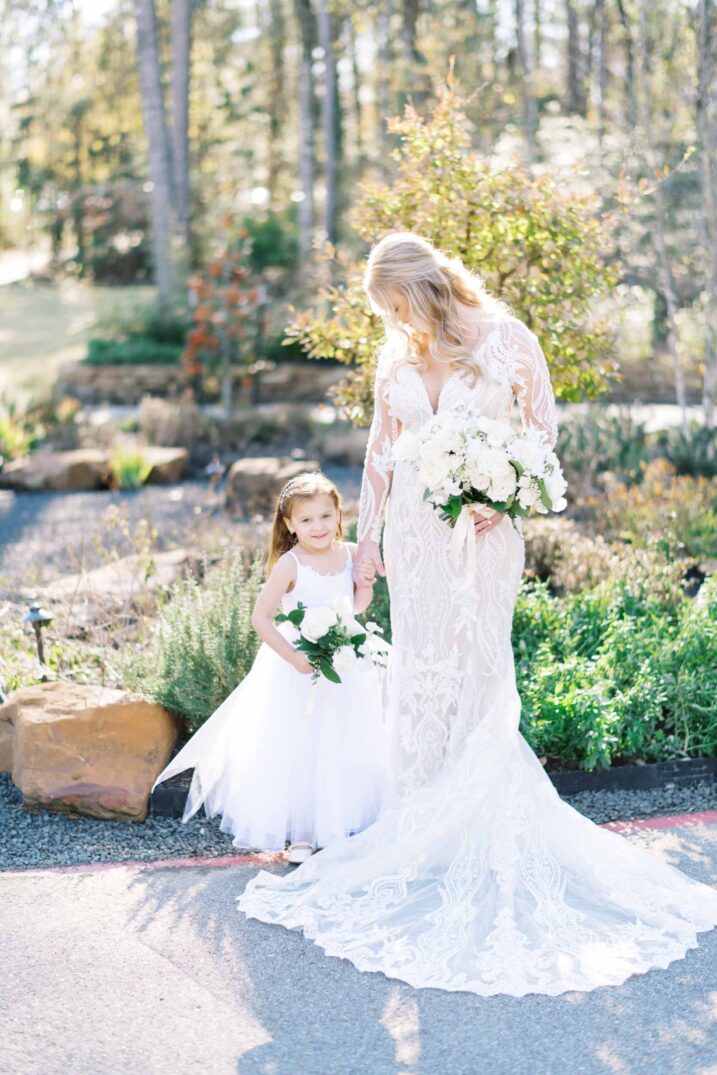 Houston wedding bride holding hands with her flower girl outdoors