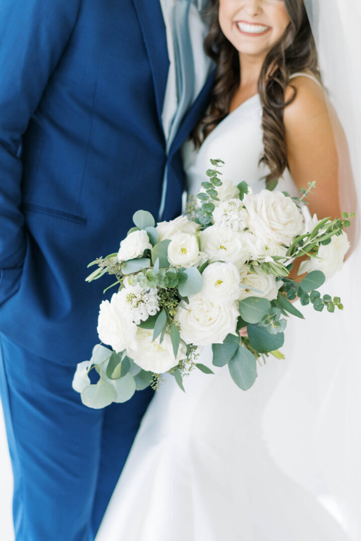 out of focus shot centered on white rose and eucalyptus bouquet