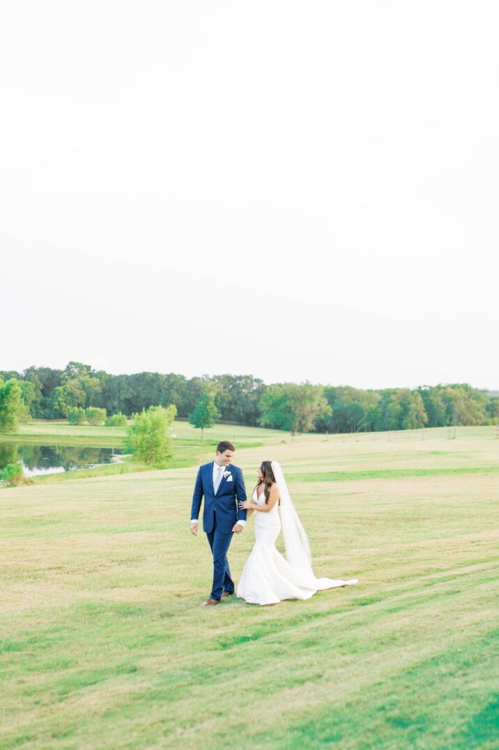 bride and groom walking together outside The Farmhouse wedding venue in Houston 