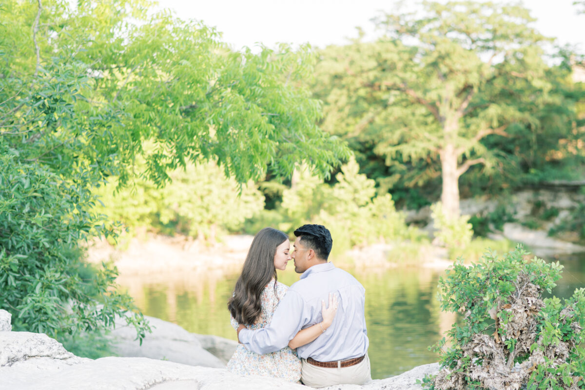 mckinney falls engagement rocks couple sitting with noses touching