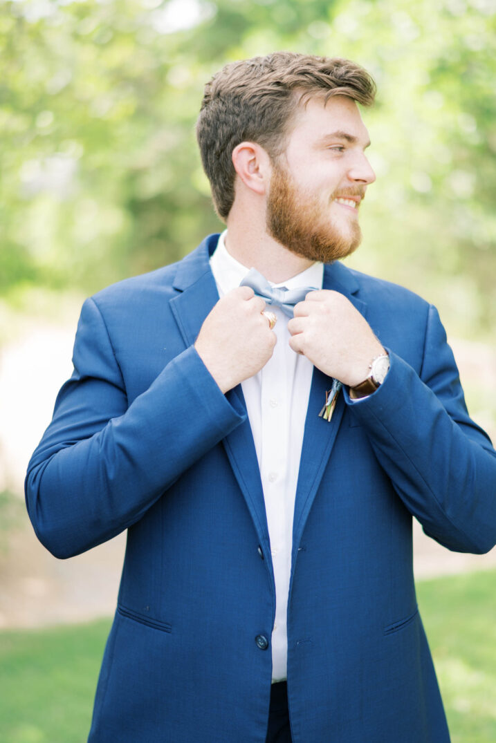 timeless texas springtime wedding groom fixing his light blue tie