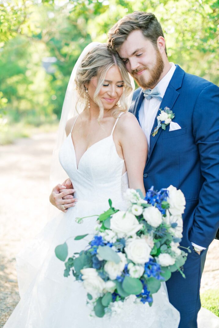 bride and groom portraits with blue floral arrangement timeless texas spring wedding