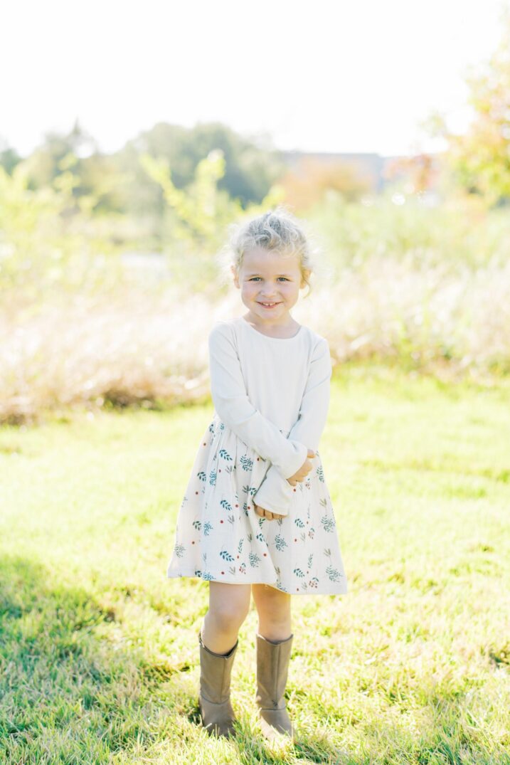 little girl wearing cowboy boots and white dress for Christmas card family photos