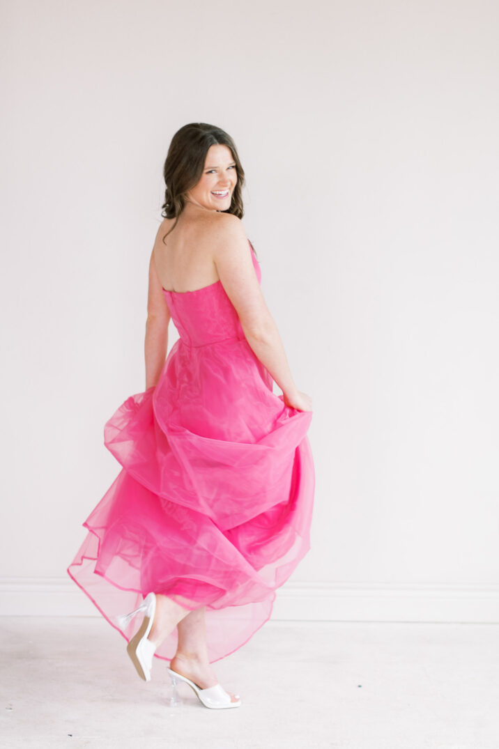 spinning in hot pink maxi dress in studio branding photoshoot