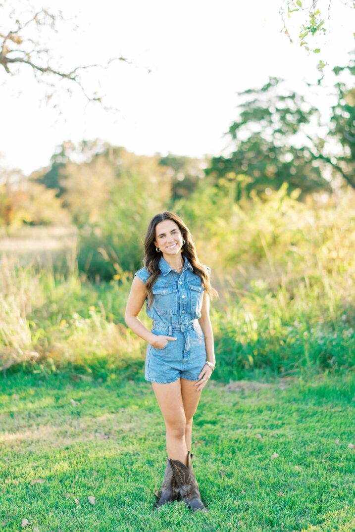 College Station senior portraits for Texas A&M student wearing brown cowboy boots and a denim overall romper