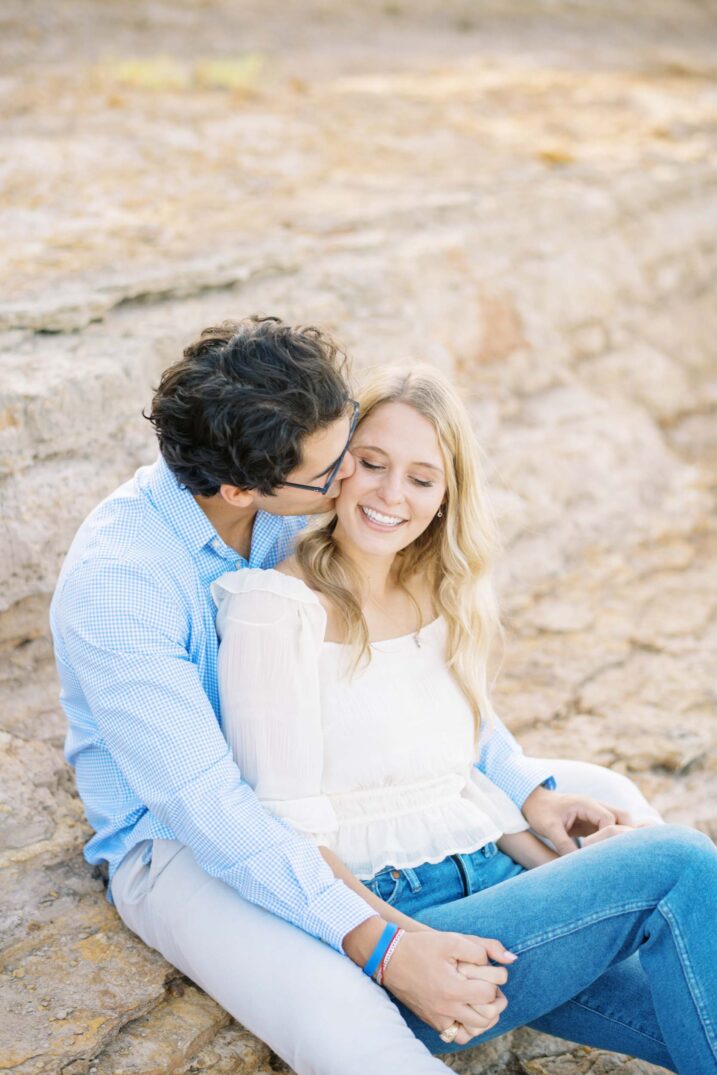 Dallas waterside engagement photos sitting on top of large rock cliff