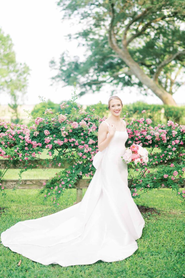 hill country bridal backyard wedding with pink flowers and elegant long dress train
