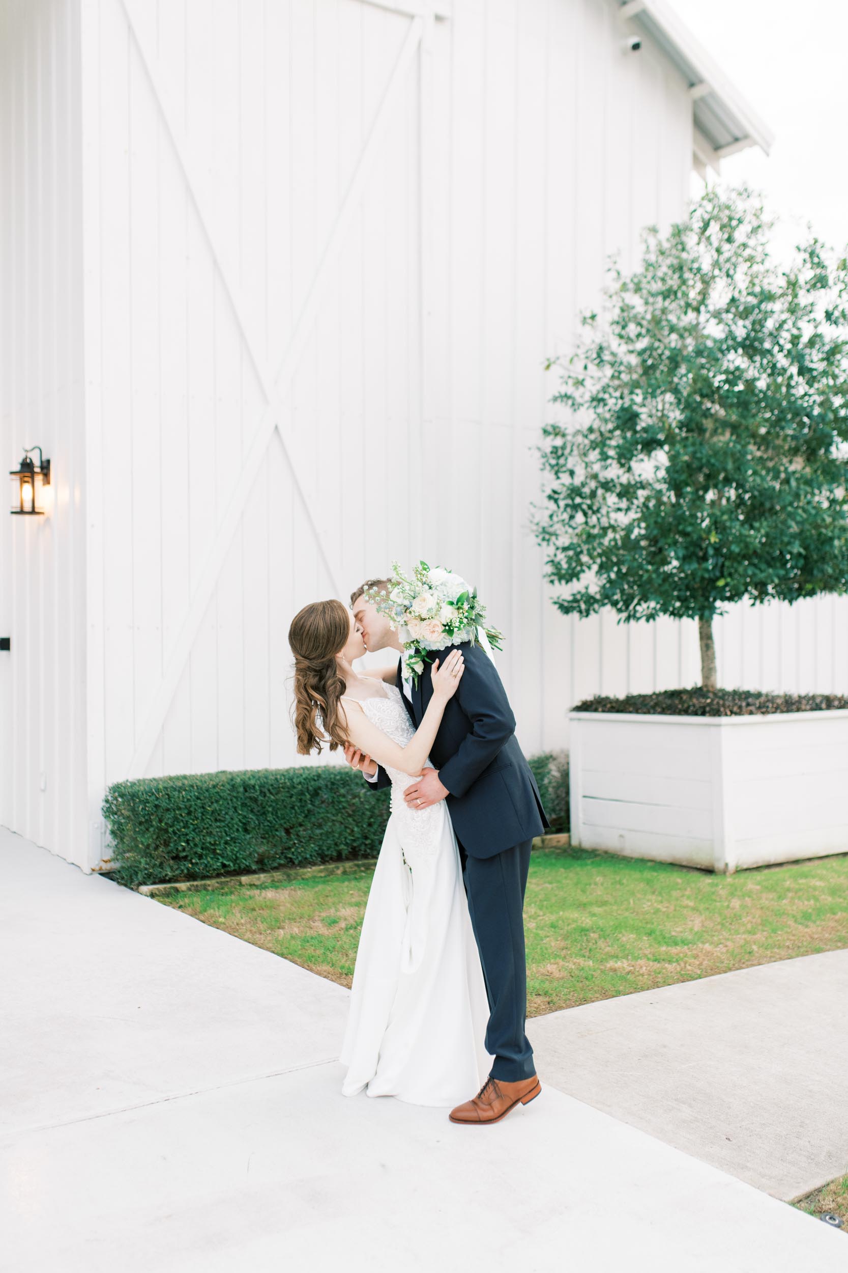 farmhouse wedding Houston couple kissing outside venue
