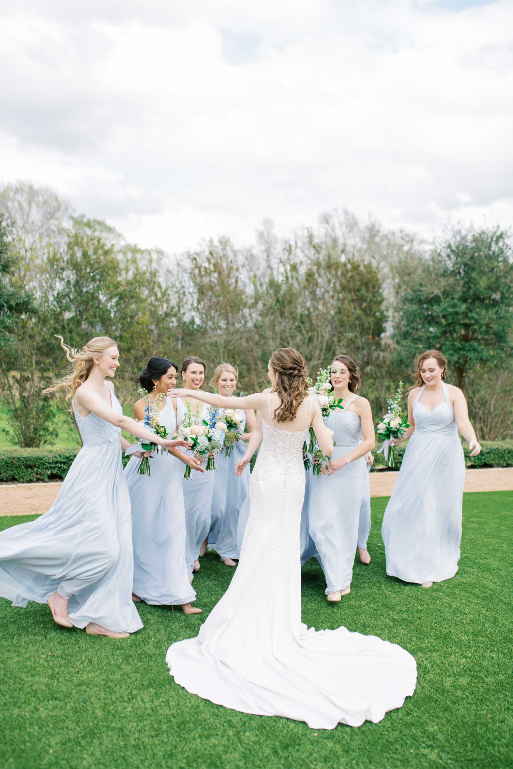 blue farmhouse wedding Houston bridesmaids hugging bride after first look