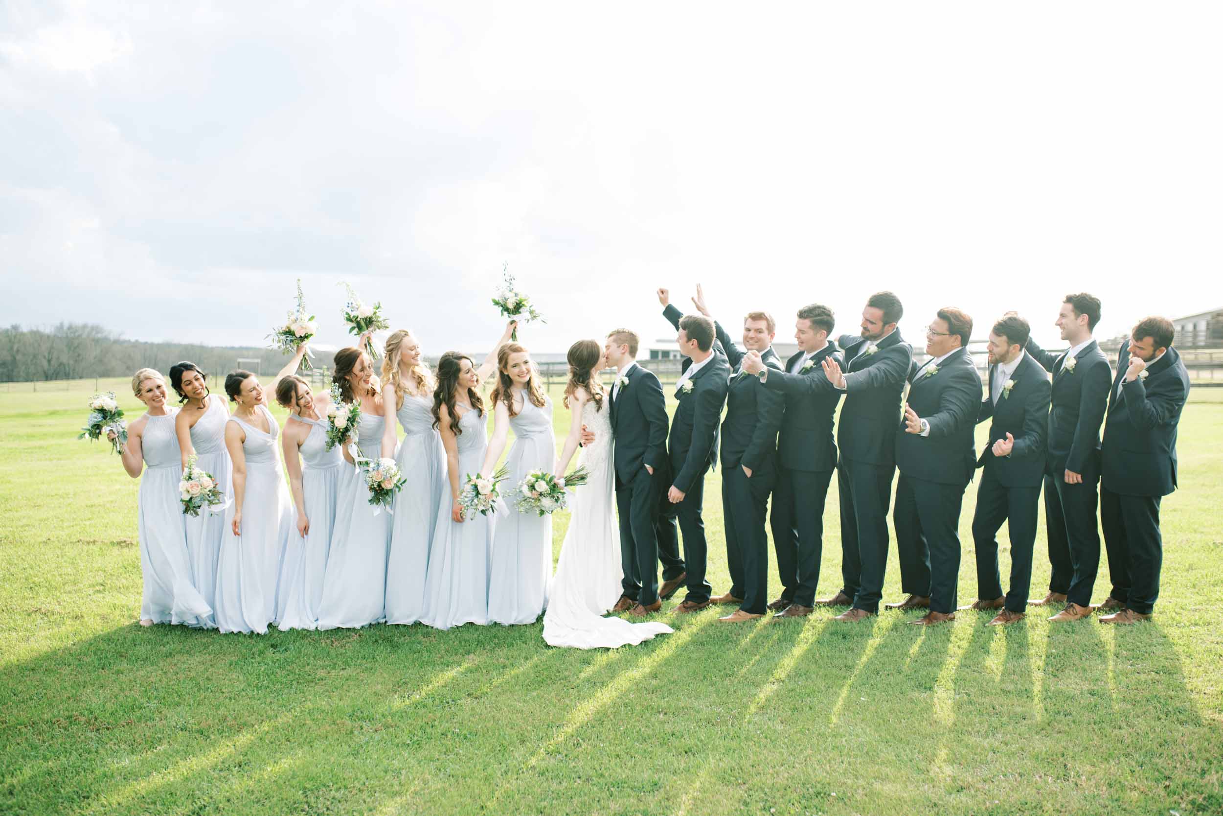 entire wedding party celebrating outside blue farmhouse wedding Houston