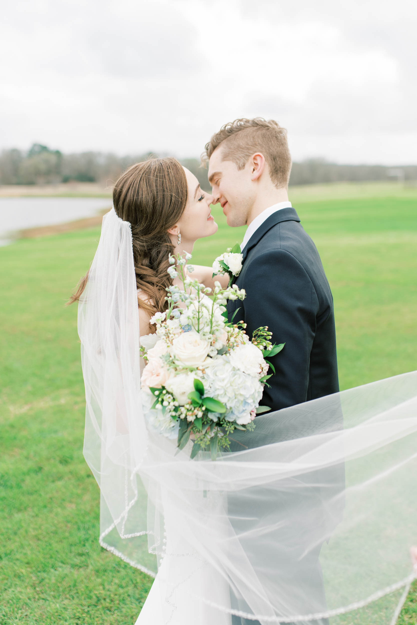 outdoor bride and groom portraits with windswept veil