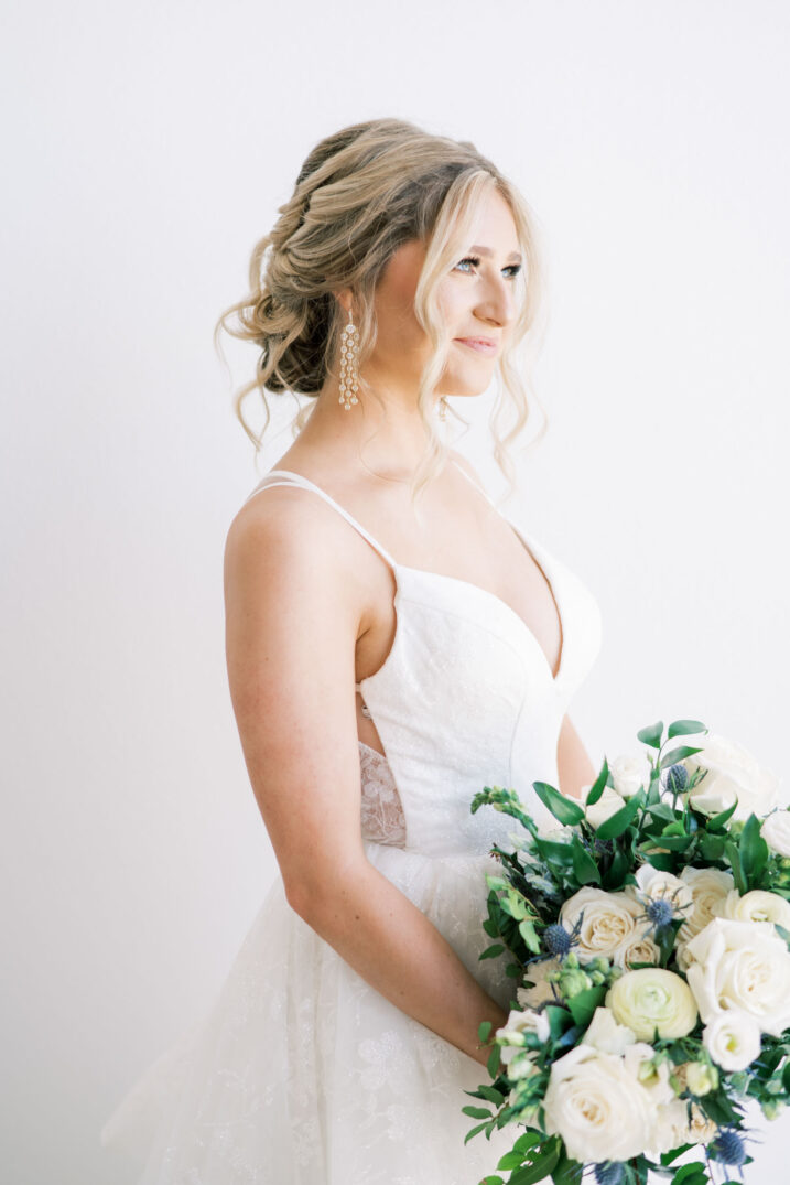 modern studio bridal session side profile of bride and white rose and greenery bouquet