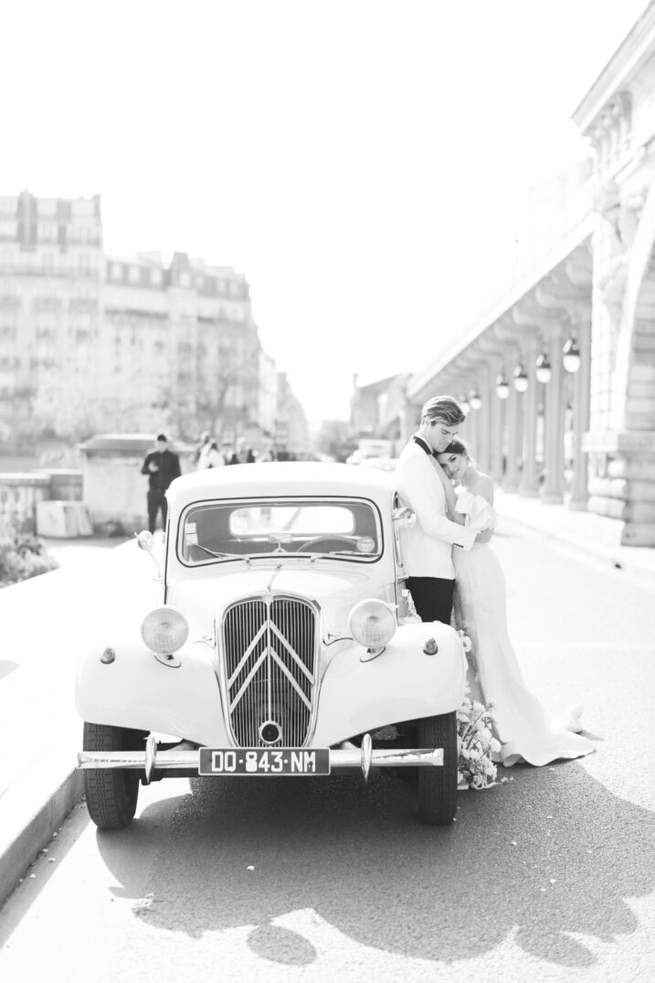black and white shot of couple in the street with a vintage car in Paris