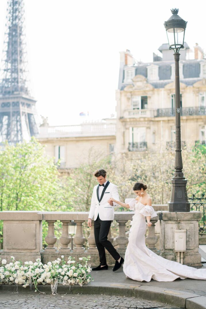 bride and groom couple walking on the street in front of the Eiffel tower