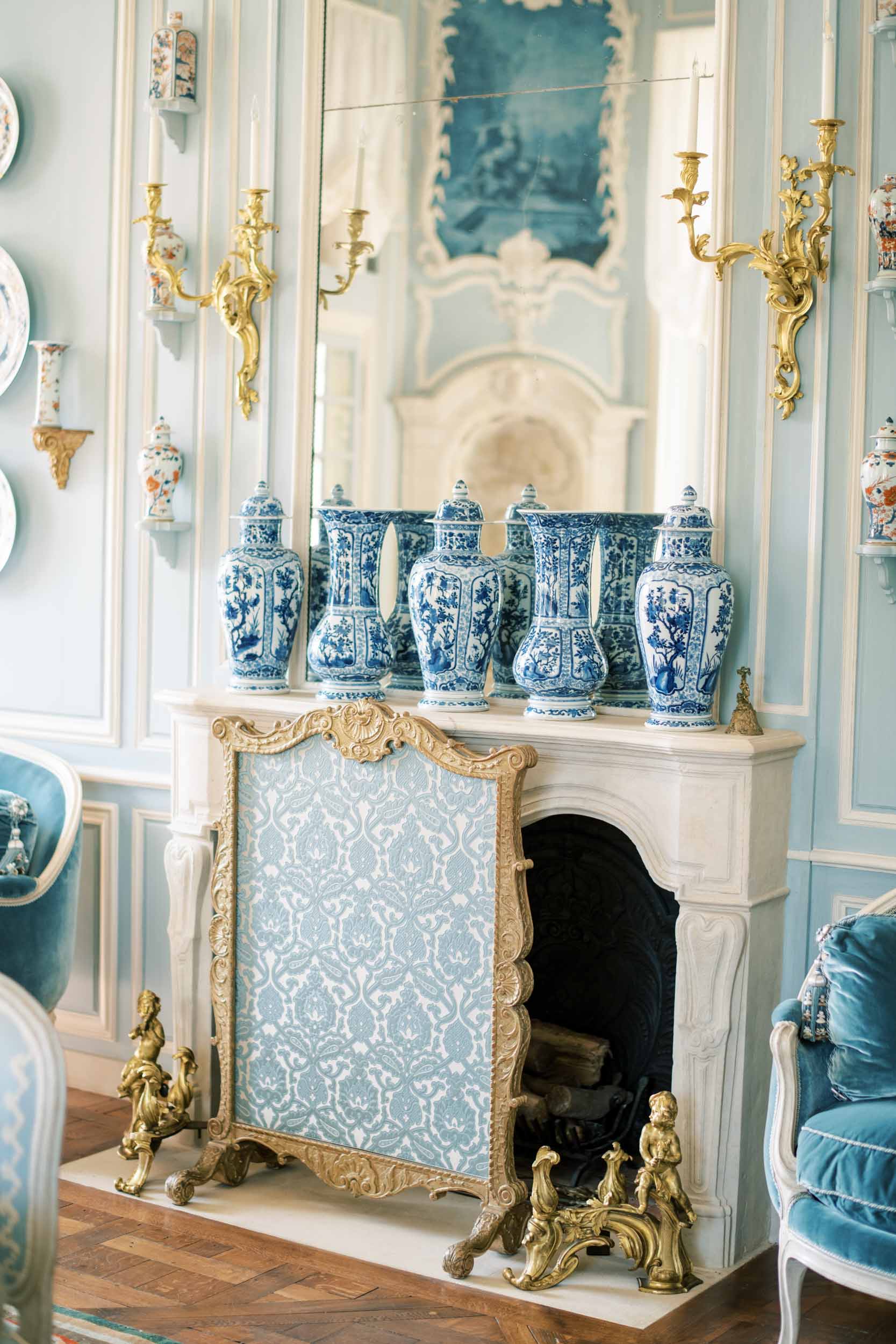 blue and white china on top of a fire place inside a Paris chateau 