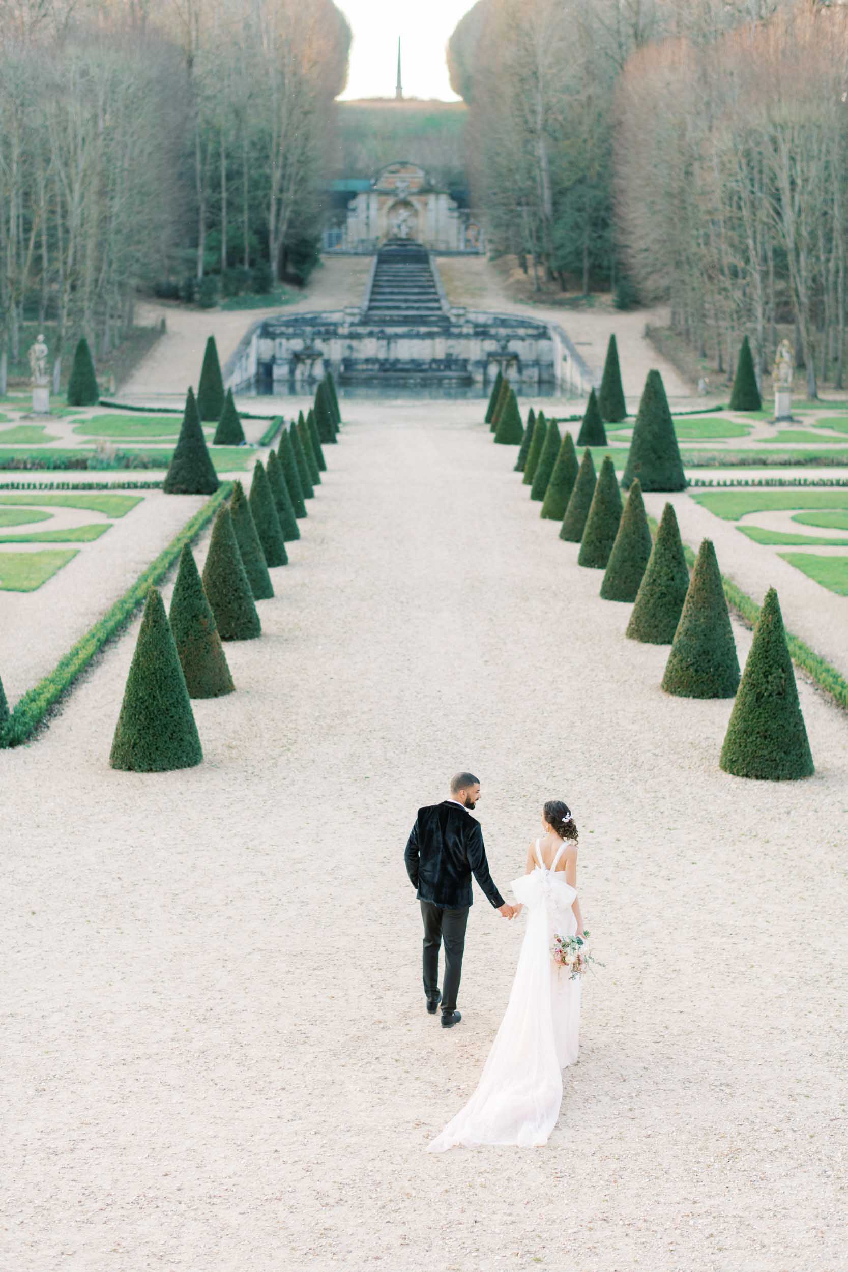 Paris chateau wedding wide shot of couple walking in the courtyard