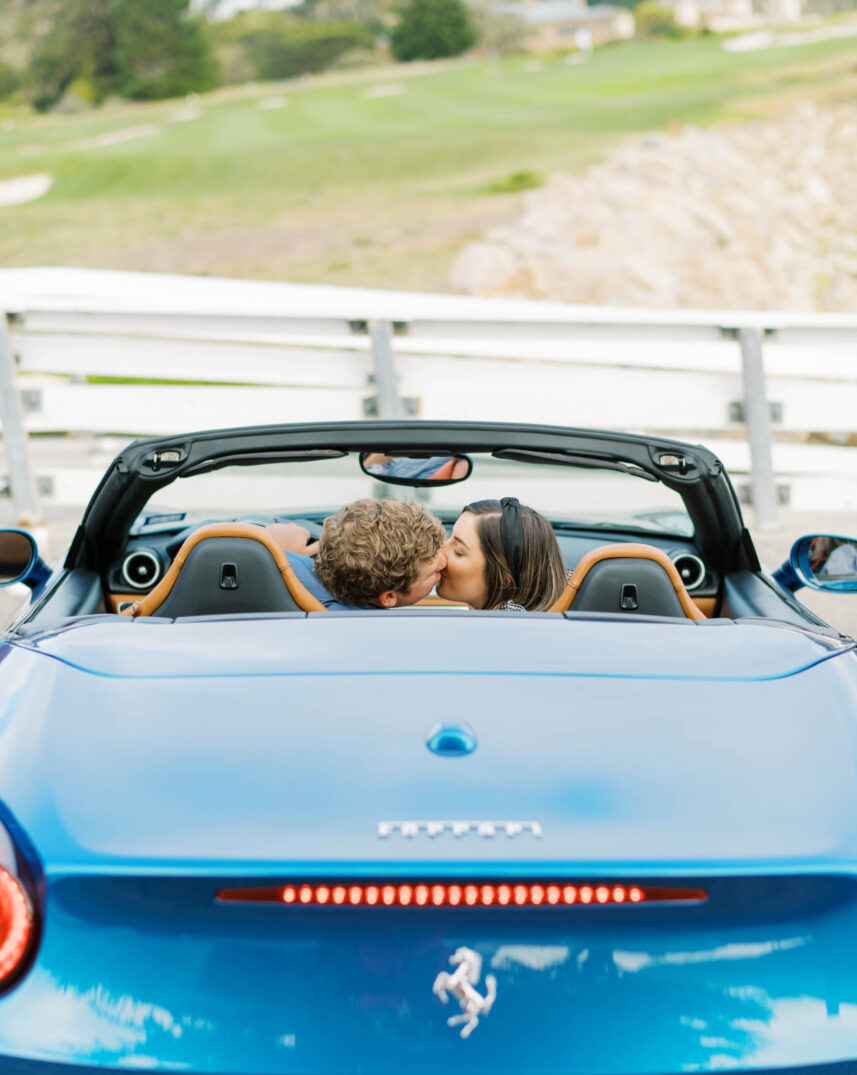 newly engaged couple kissing before driving off in a bright blue Maserati