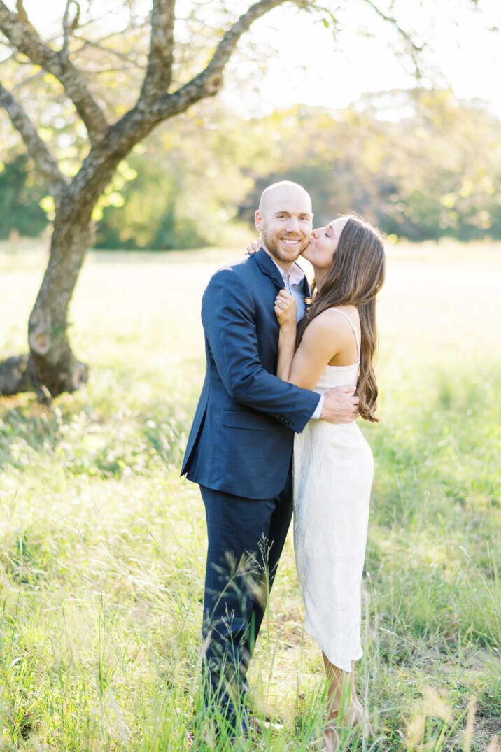 engaged couple in navy suit and white midi dress 