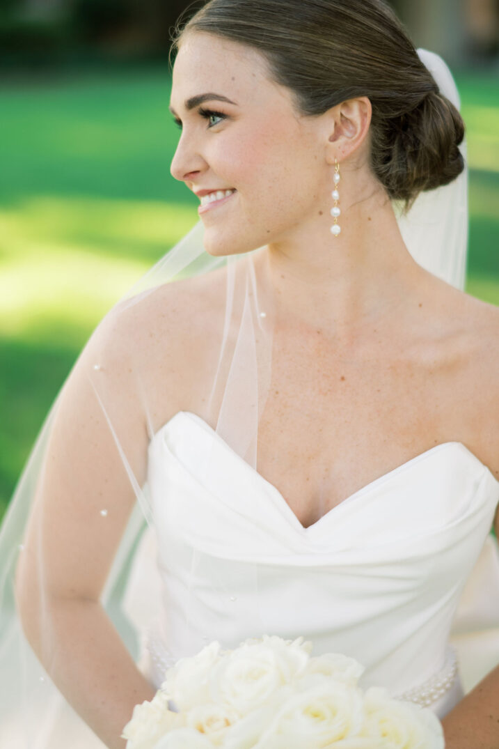 bridal session with pearls scattered across veil and pearl drop earrings