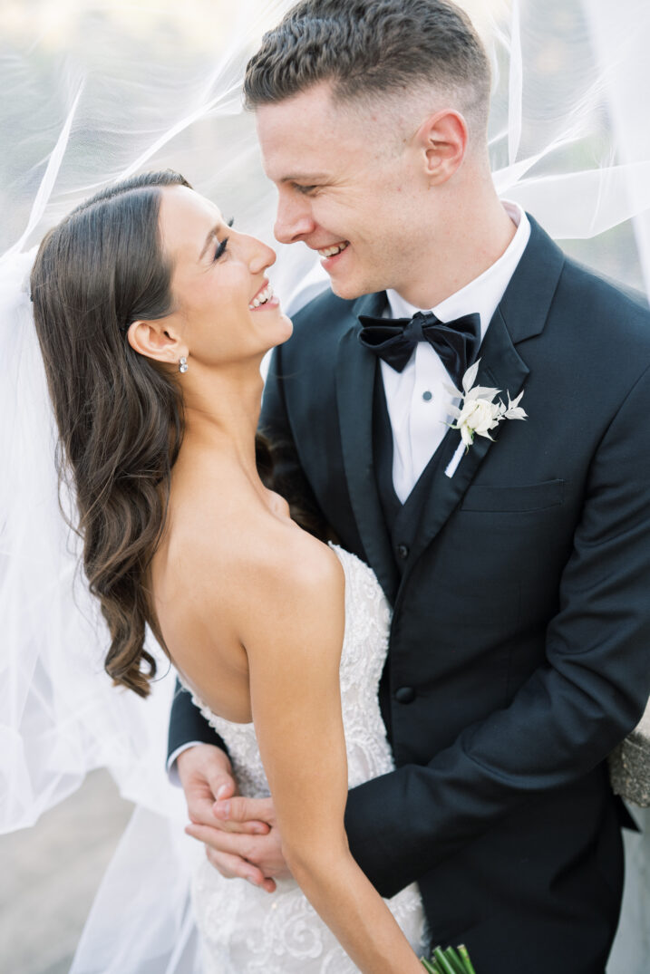 bride and groom under veil hug embrace black and white Italian inspired wedding style 