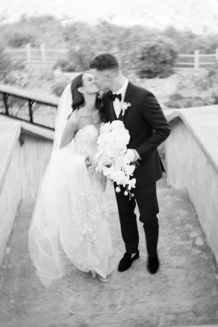 black and white photo kiss wedding day Italian inspired blurry floral bouquet joyful