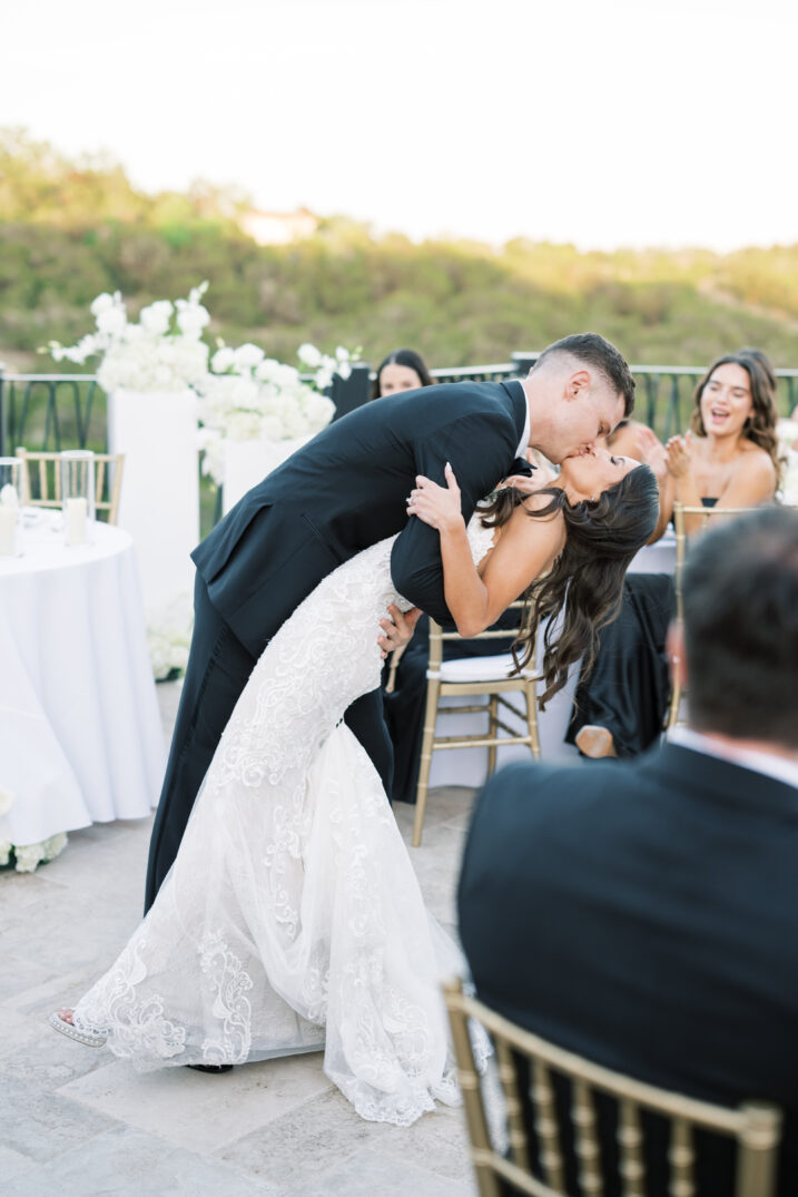 first dance dip kiss wedding black and white Italian inspired bow tie outside venue  