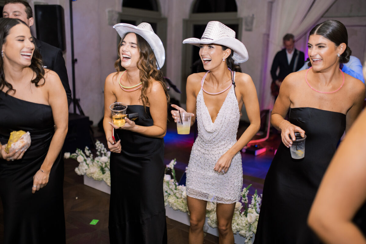 bride with bridesmaids dancing at reception sparkly cowboy hat spunky