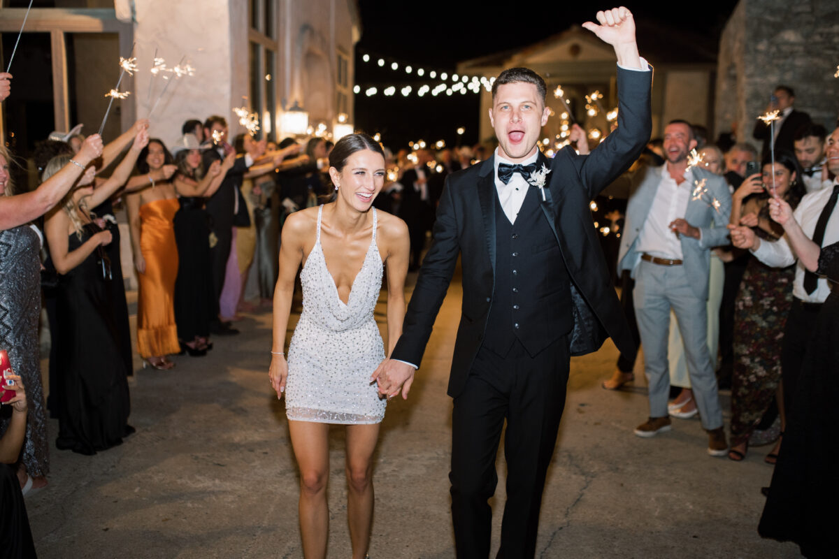 groom and bride fun sparkler exit outside venue reception dress