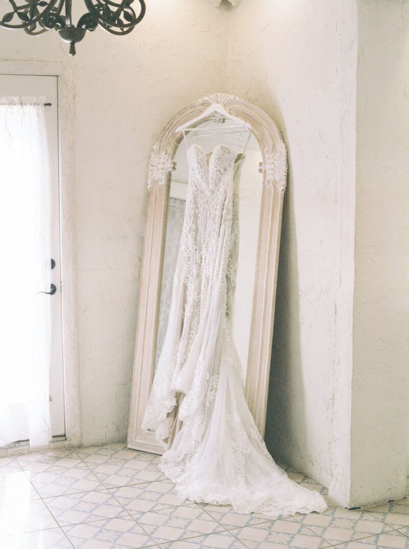white wedding dress hanging over mirror window Italian inspired 