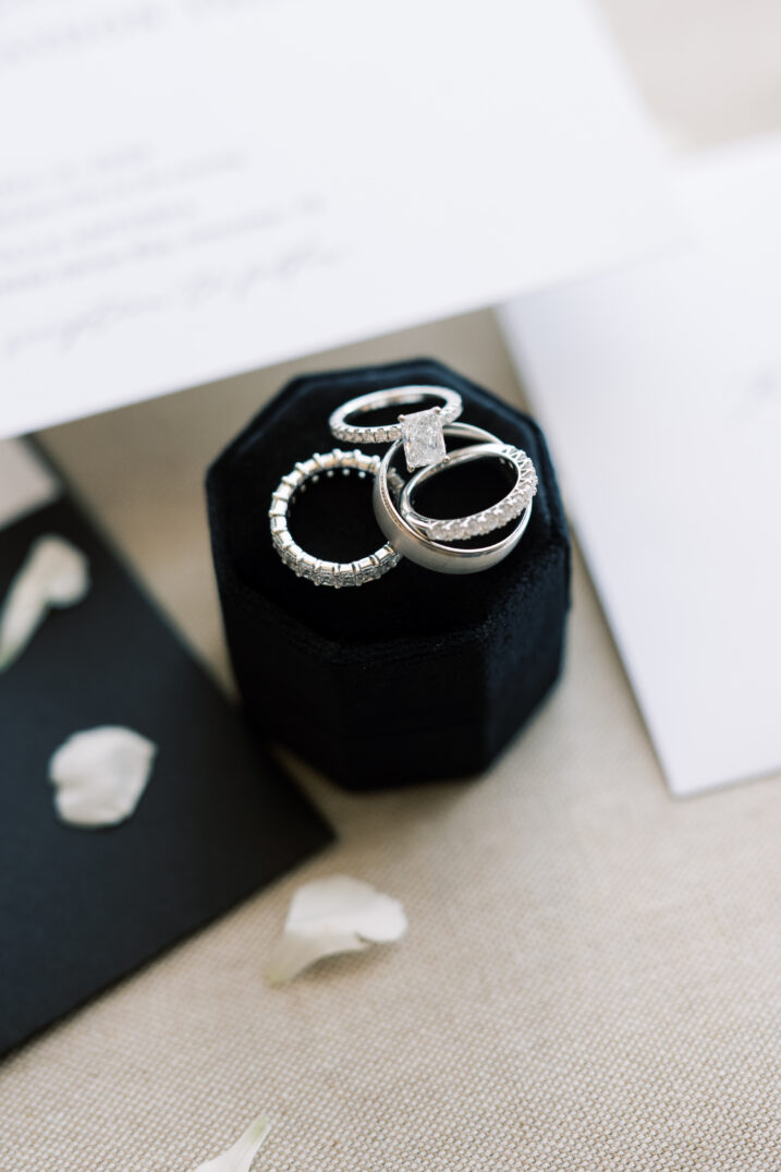 close up wedding rings details with florals and ring box