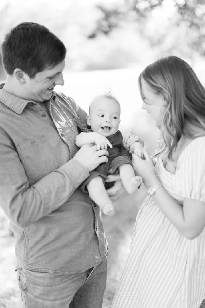 baby laughing with parents