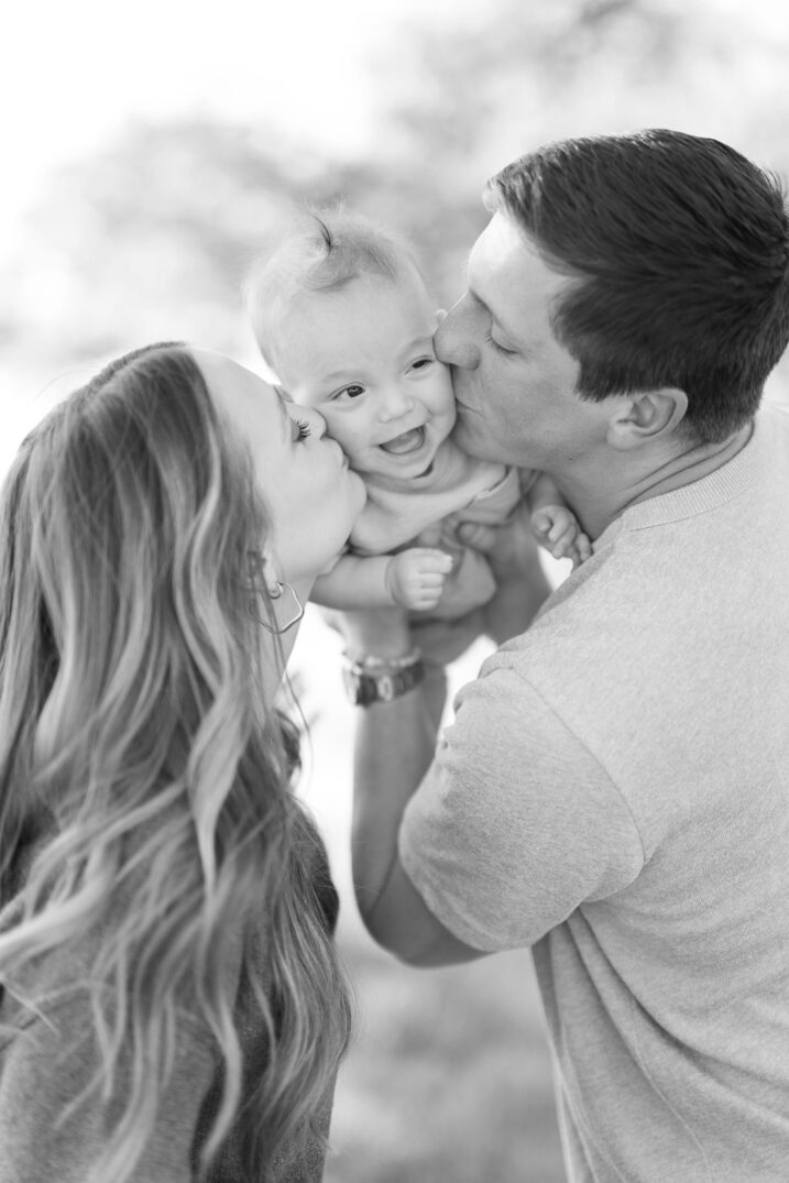 parents kissing baby