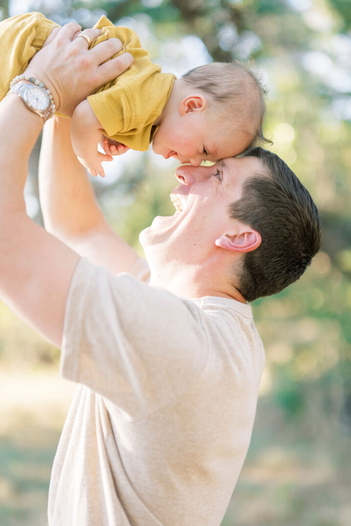 dad holding up baby